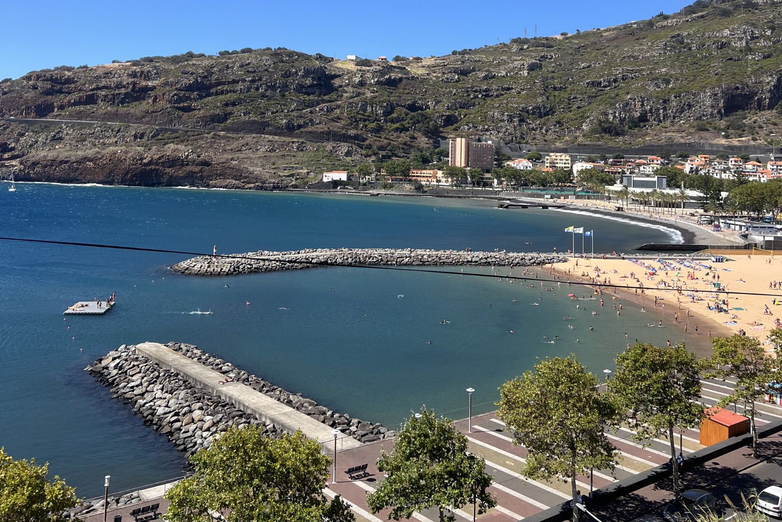 Machico sandy beach Madeira east coast bay with calm water and town behind